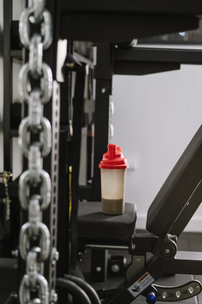 A protein shake bottle on gym equipment symbolizing fitness and health.