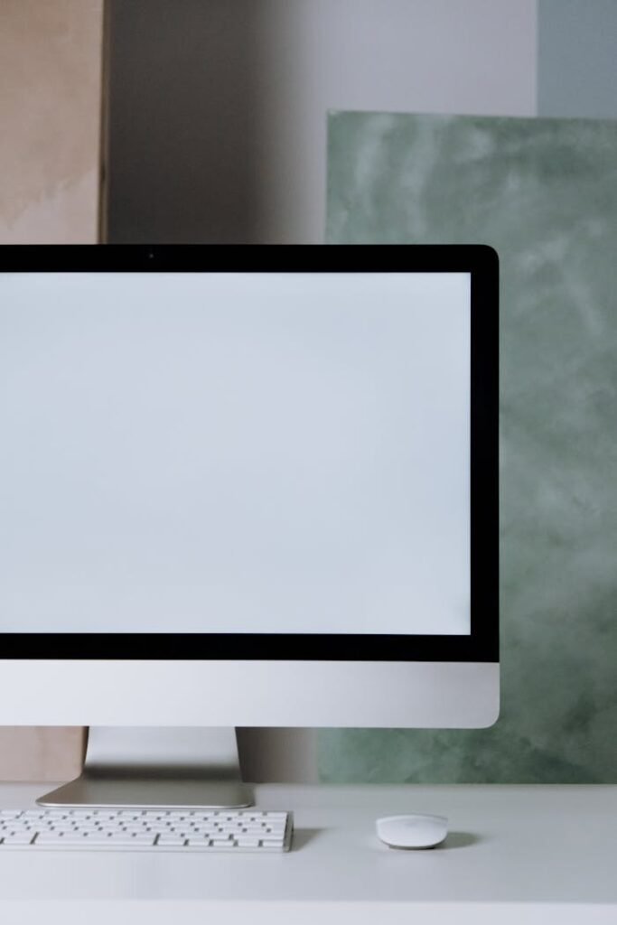 A minimalist workspace featuring an iMac with keyboard and mouse on a desk.