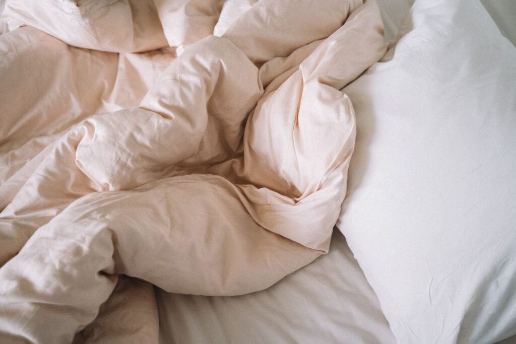 Soft crumpled bed sheets with a pillow evoke a sense of comfort and relaxation in a bedroom setting