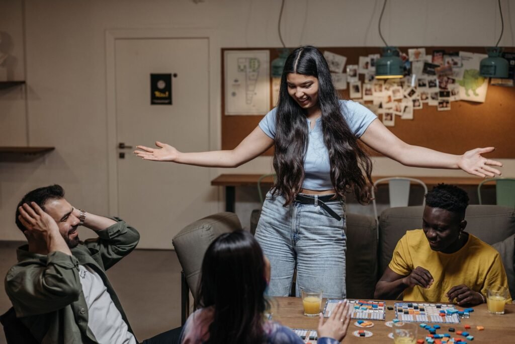 Group of friends laughing around a table during a board game night at home