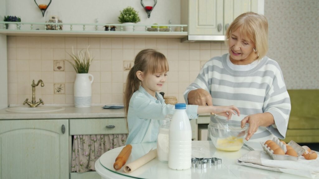 Grandmother and granddaughter baking together in a bright kitchen