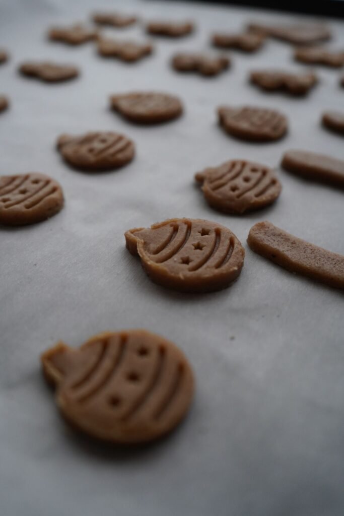 Holiday cookie dough cutouts lined up on a baking sheet
