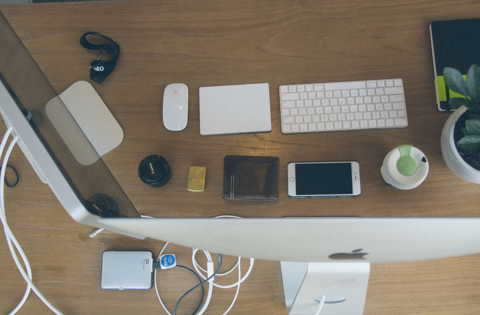 Top-down view of an organized modern desk setup featuring Apple devices and accessories