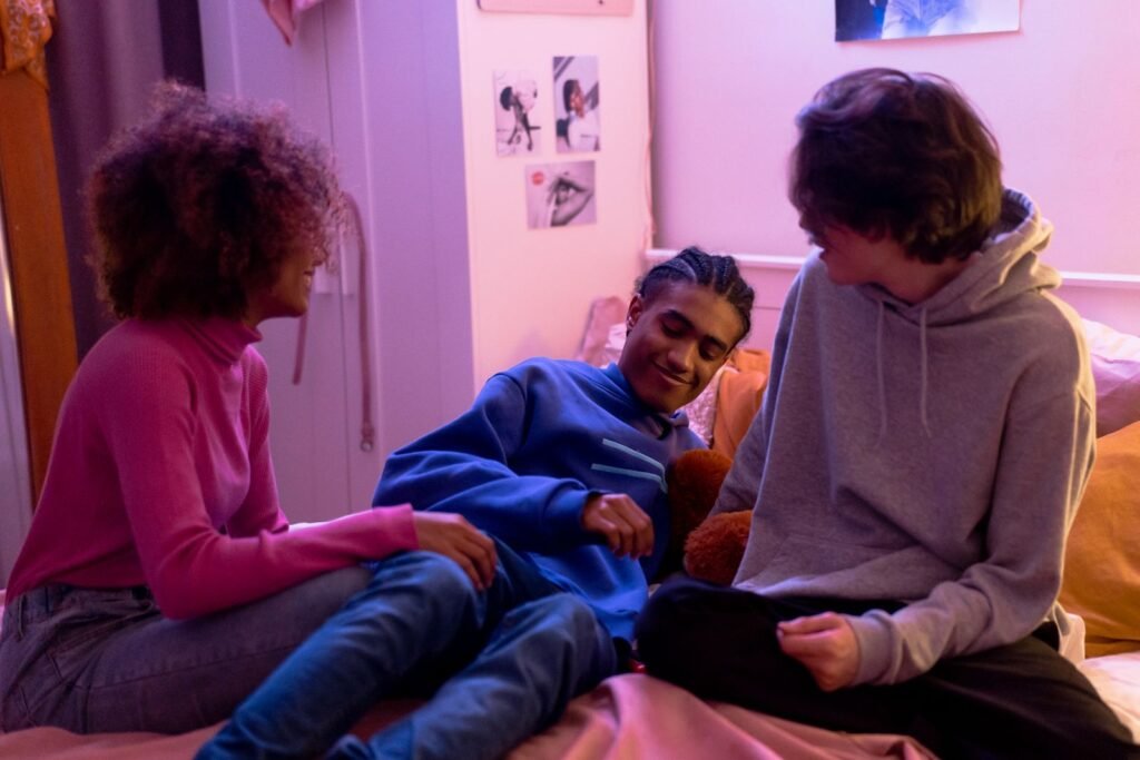 Group of teenagers hanging out in a colorful, softly lit bedroom