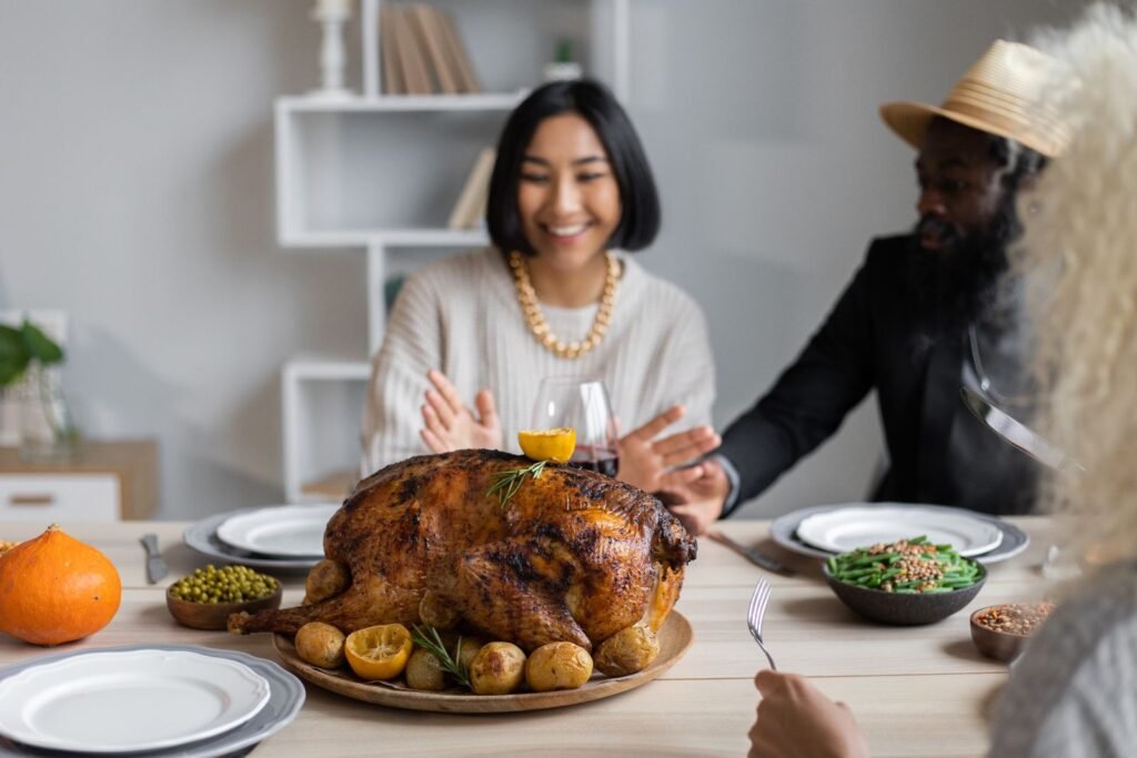 Friends gathered around a Thanksgiving dinner table with a roast turkey